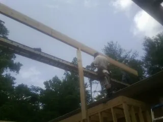 Carpenter setting a ridge beam over a new addition frame — Ice Dam Removal by Roofing Brothers in East Wareham