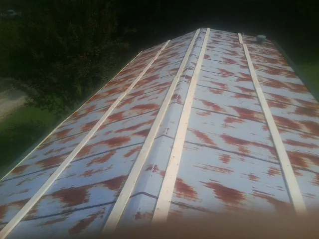 Rusted metal roof panels with new wood purlins before replacement — Storm Damage Roof Repair in East Wareham by Roofing Brothers
