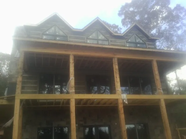 Dormers and porch framing on a large log home under construction — Roof Coating work by our crew in East Wareham