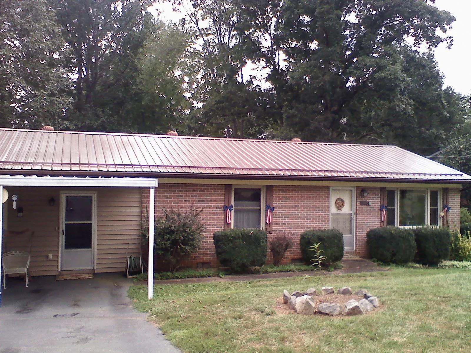 Bronze metal roof and carport on a brick ranch home — Roof Repair work by our crew in East Wareham